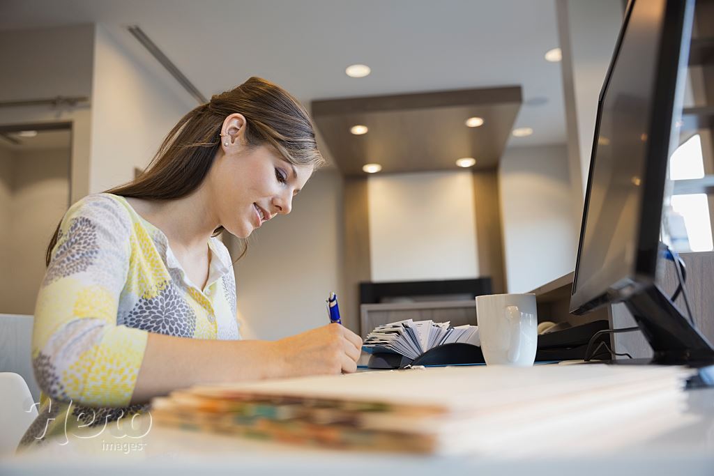 Receptionist working at front desk in dentists office | Hero Images